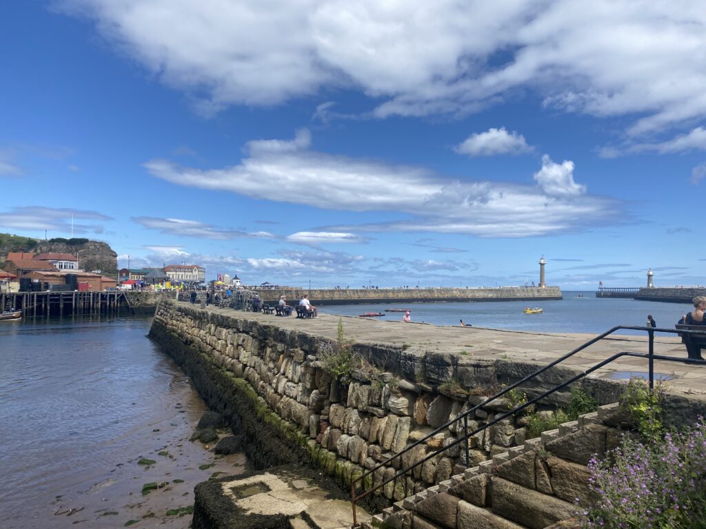 A small pier jutting out into Whitby's harbour.